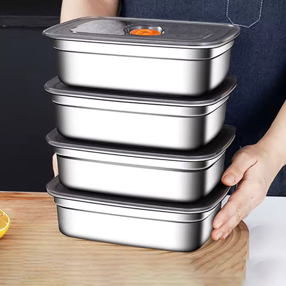 Stack of four premium silver stainless steel bento boxes with airtight grey lids on a wooden cutting board.