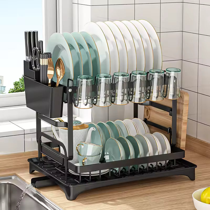 Black 2-tier dish drying rack with a top plate rack, bottom bowl tier, cutlery holder, and drainboard with a spout on a kitchen counter.