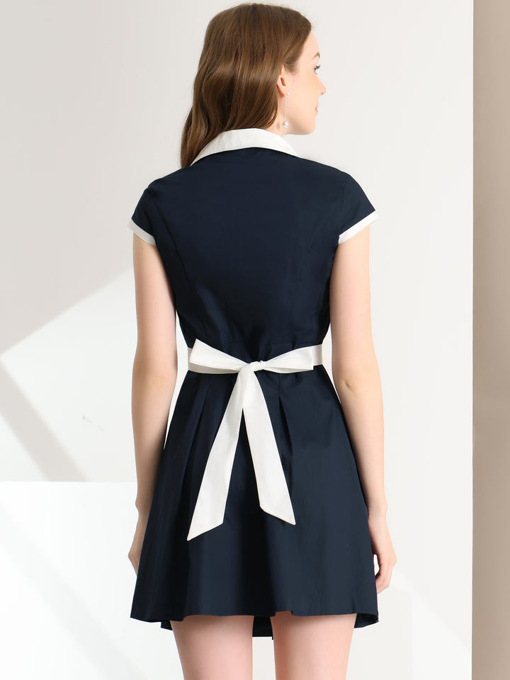 Navy dress with a white belt worn by a model on a plain background
