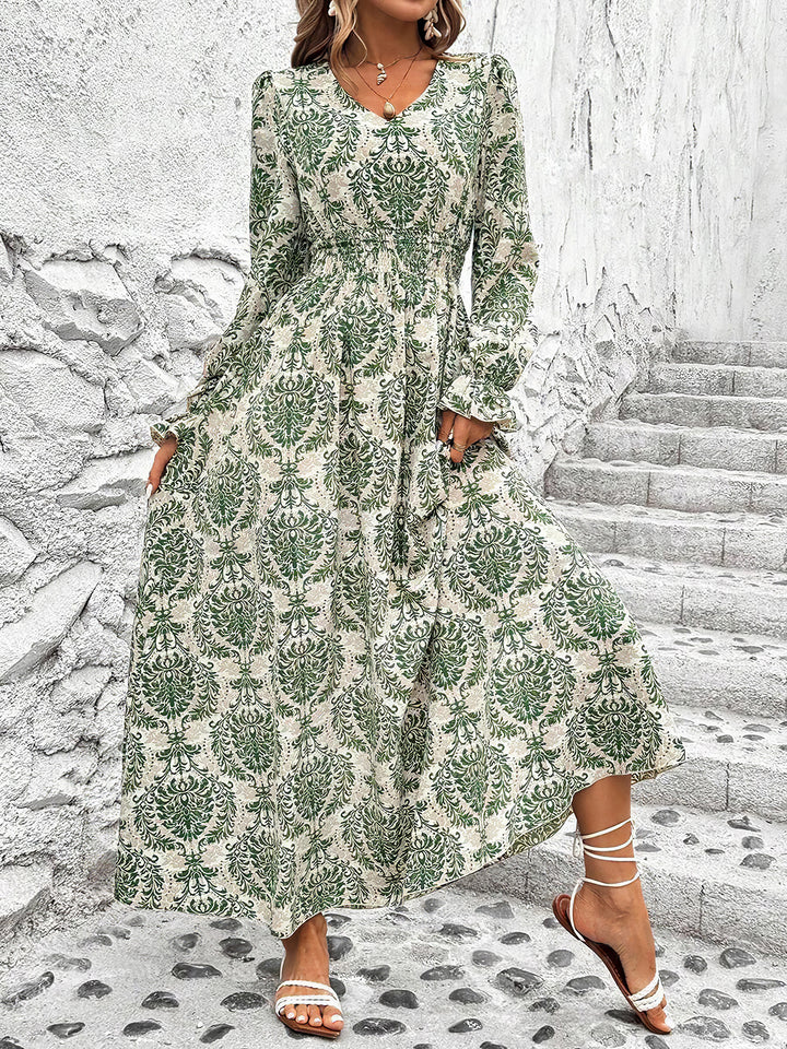Woman wearing a green and white patterned dress on stone steps.