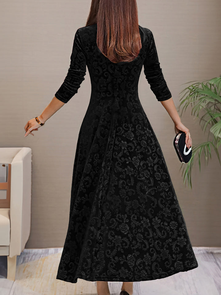 Woman wearing a black patterned dress in an indoor setting