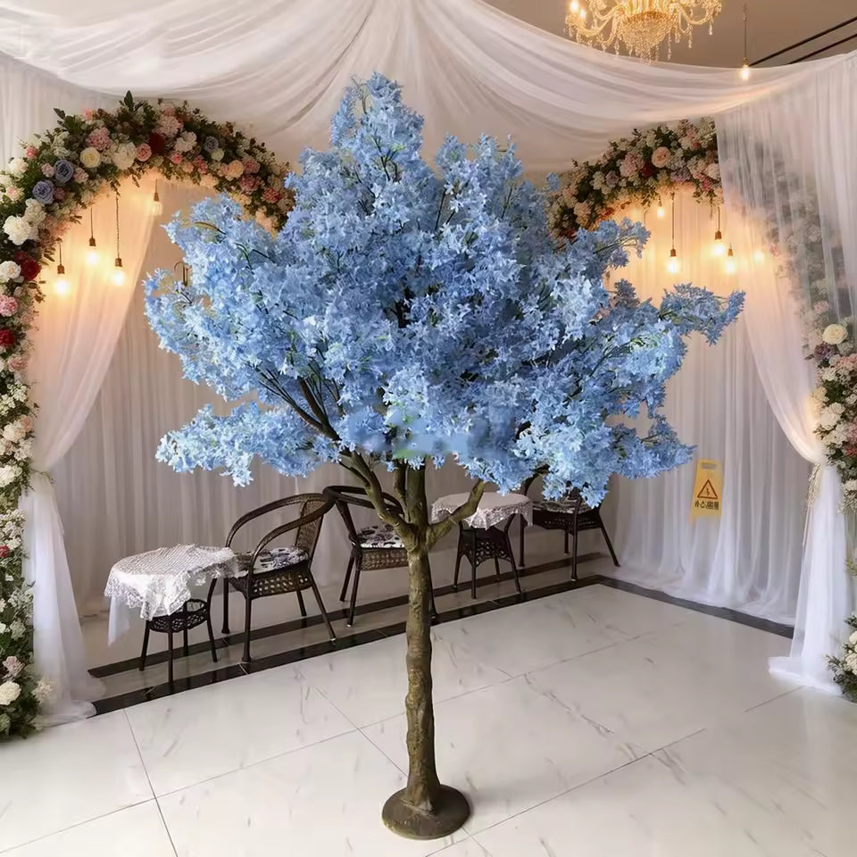 Mini blue artificial cherry blossom tree with silk flowers and fence for wedding table decoration and indoor event decor.