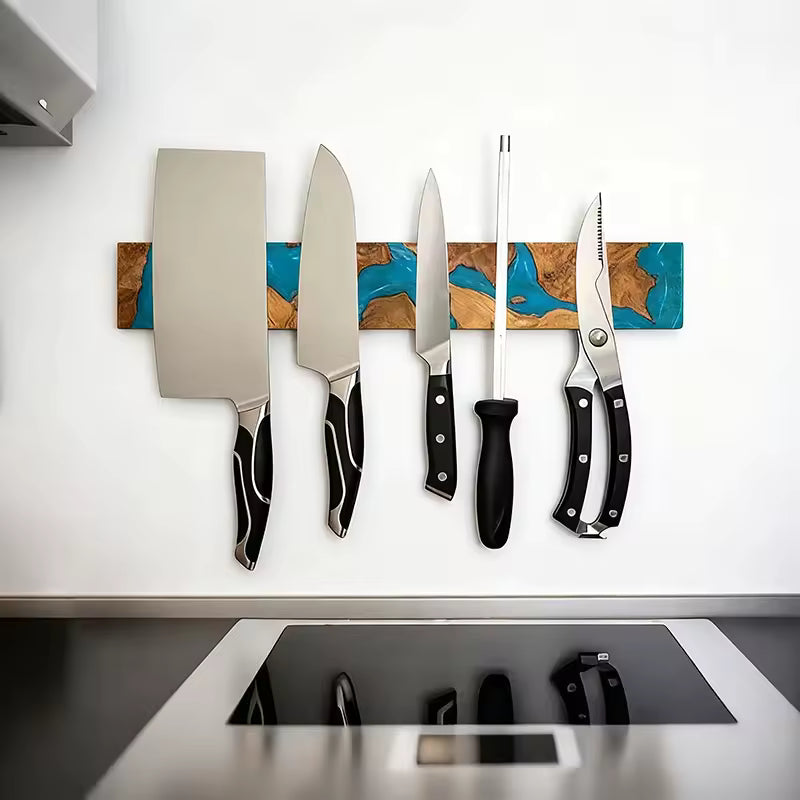 40cm magnetic knife holder strip made of acacia wood and blue epoxy resin, mounted on a white wall holding various kitchen knives.