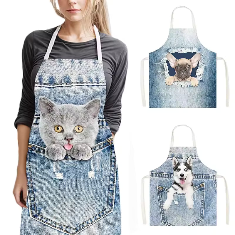 Funny kitchen apron with a 3D denim print featuring a cute kitten peeking out of a pocket, worn by a woman.
