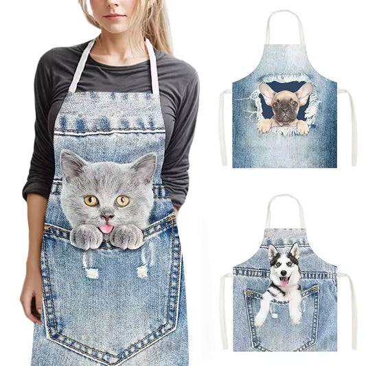 Funny kitchen apron with a 3D denim print featuring a cute kitten peeking out of a pocket, worn by a woman.