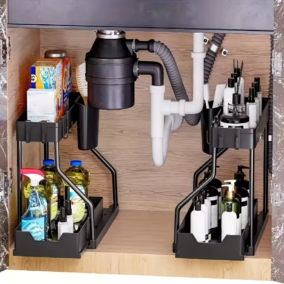 Black 2-tier L-shape sliding under-sink organizer holding cleaning bottles and detergents around bathroom plumbing.