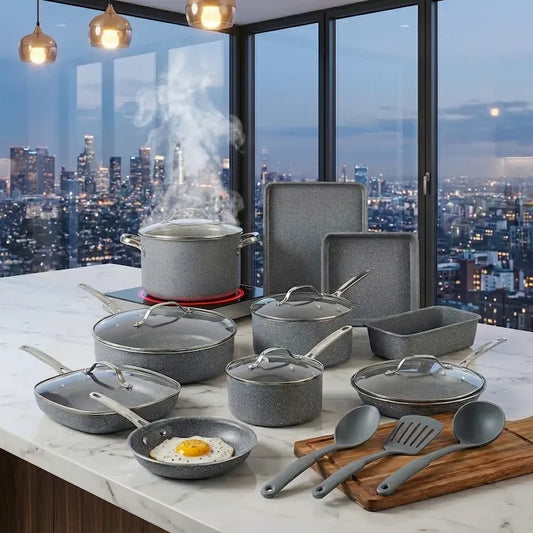Complete 12-piece speckled gray granite nonstick cookware set arranged on a white marble kitchen island at dusk with a steaming stockpot on an active glowing induction hob