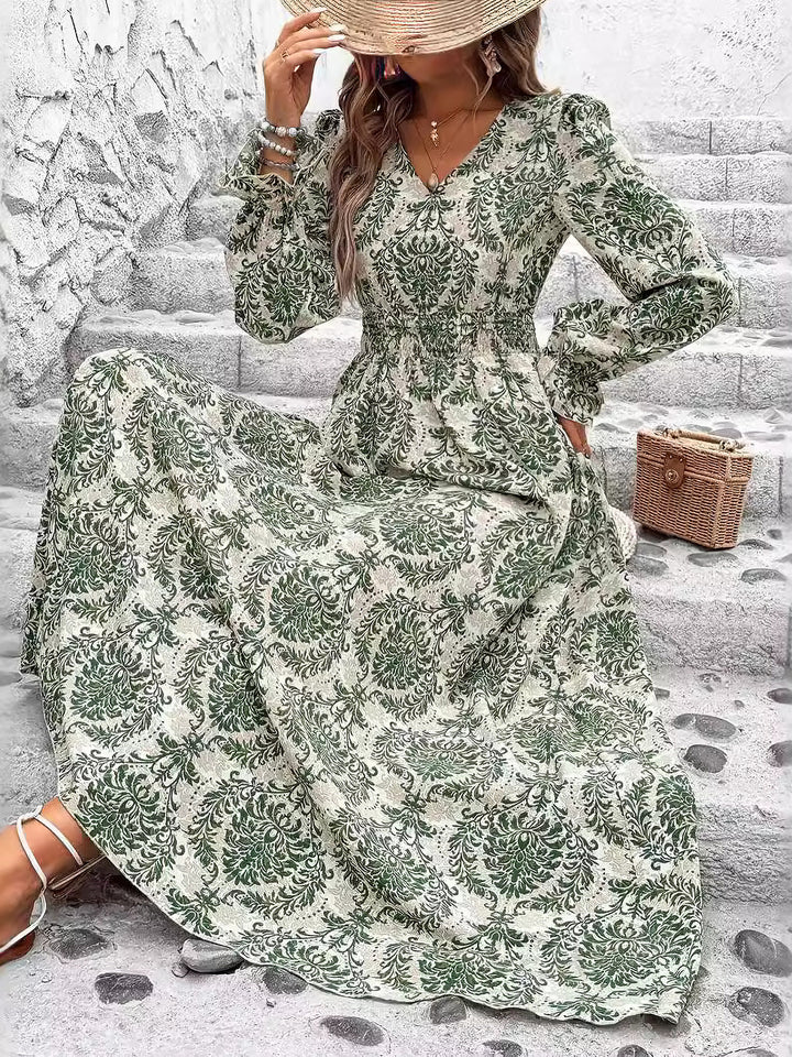 Woman wearing a green floral dress sitting on stone steps.