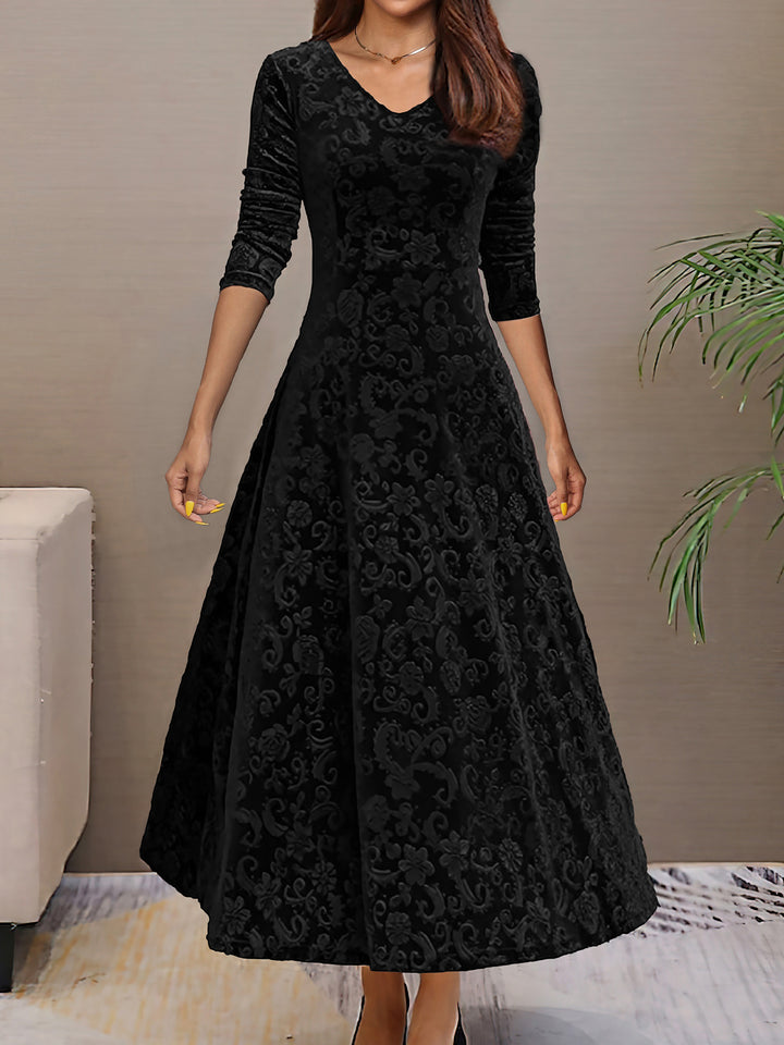 Woman wearing a black lace dress against a neutral background