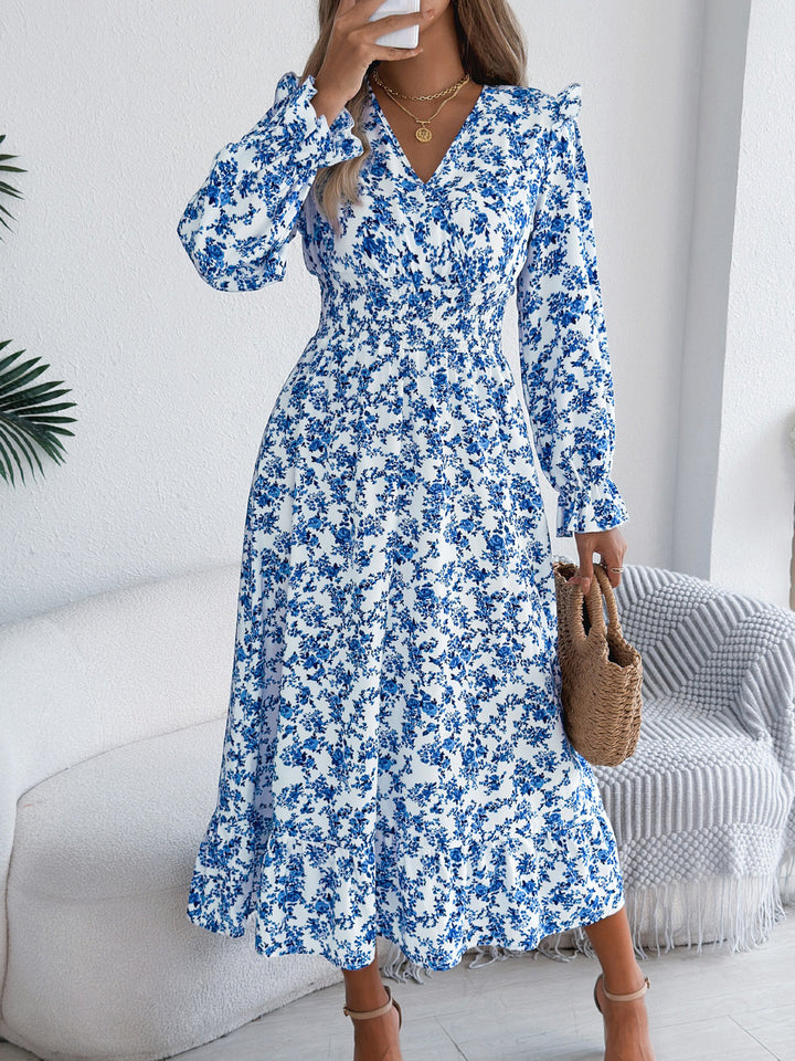 Woman wearing a blue floral dress in a modern living room.